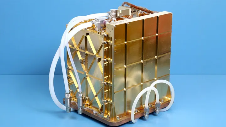Gold-colored scientific apparatus with interlocking panels, tubing, and fittings set against a blue background