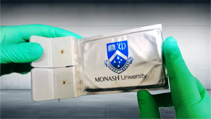 Gloved hands holding a Monash University Lithium Sulfur Battery