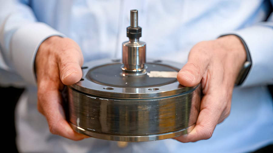 Someone holding a small flywheel in both hands