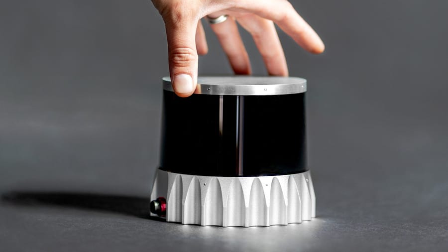 A hand reaching to pickup a traffic camera